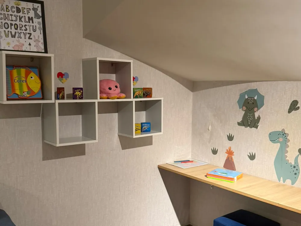 Cantinho com prateleiras de livros e bancada de desenho